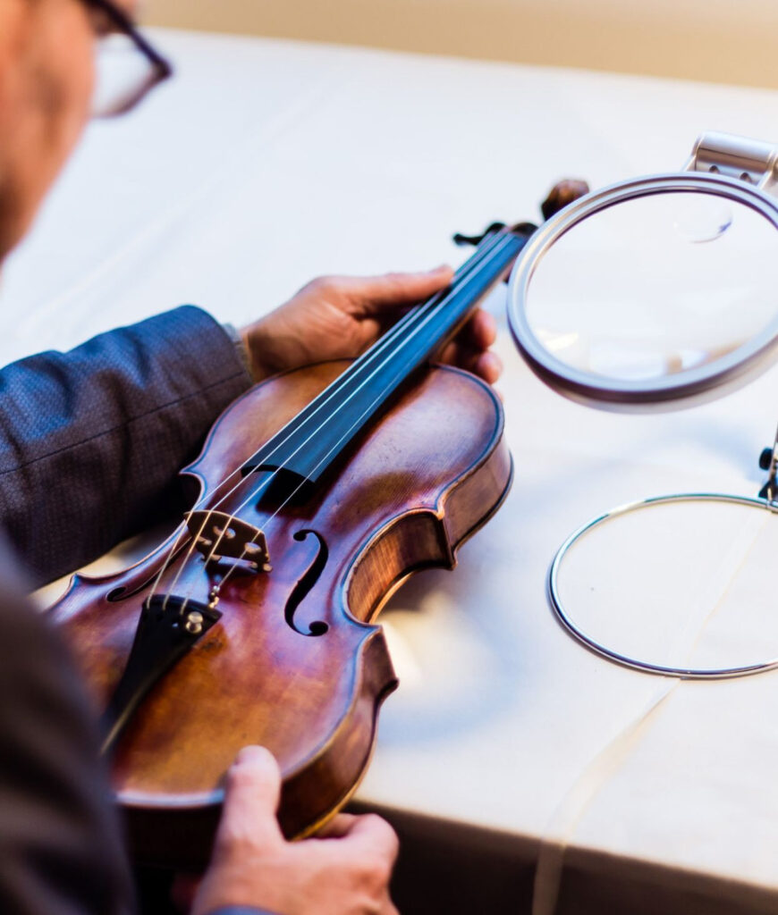 A specialist examining a violin